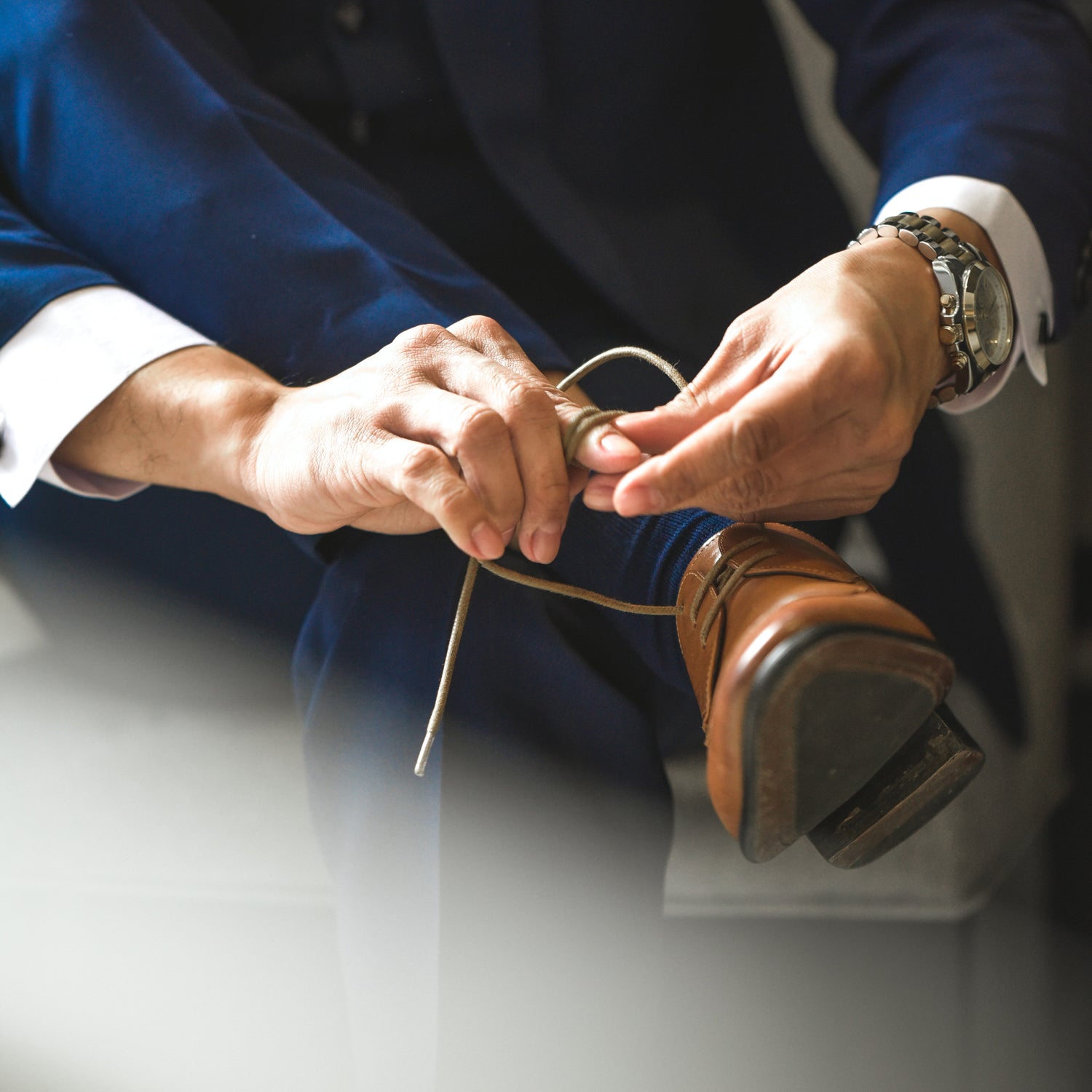 Smart Dressed Man with nice watch, Sitting and tying laces