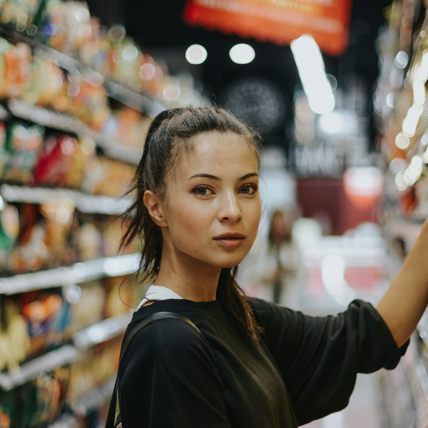 Lady with dark top food shopping and looking at camera