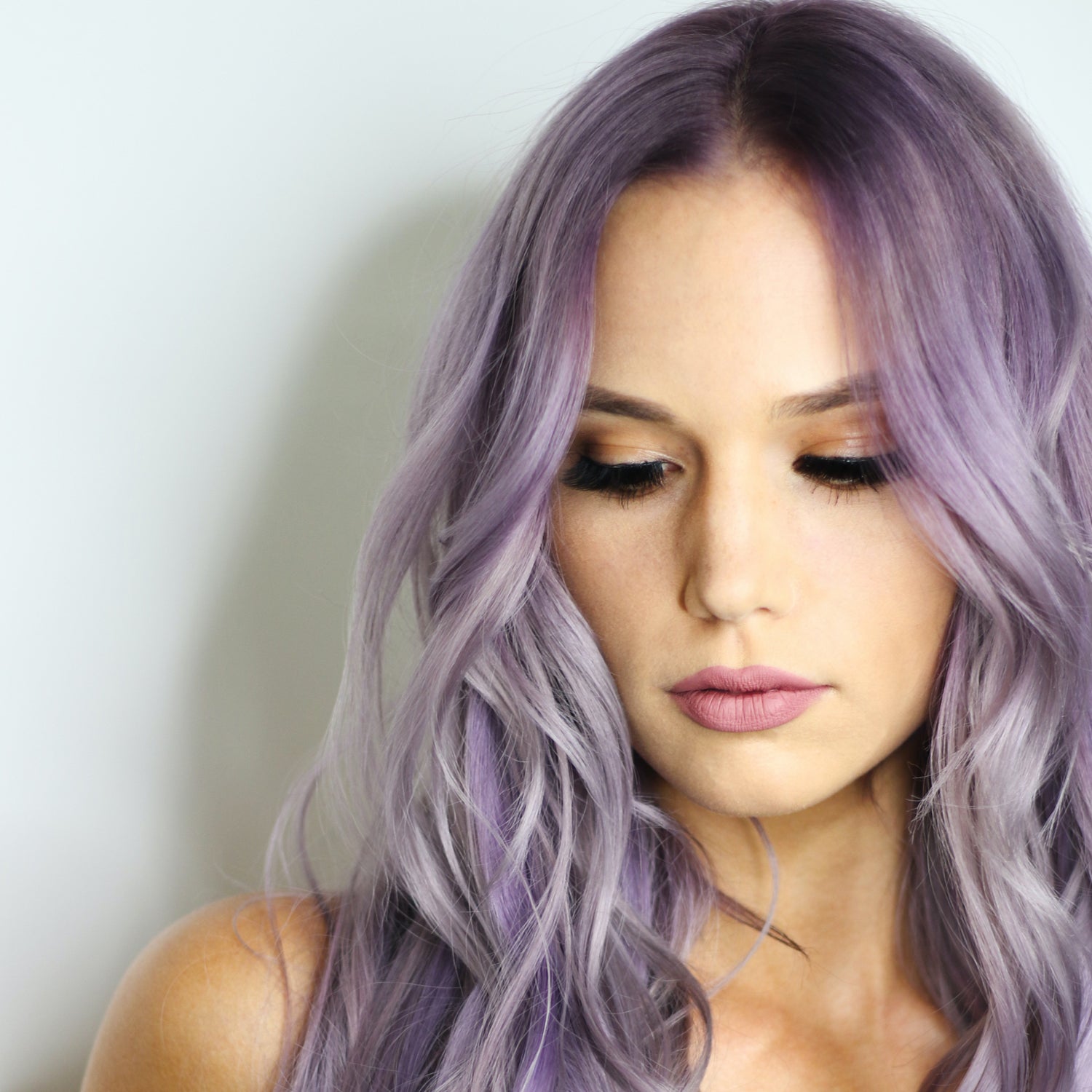 Pretty women with purple hair casually looking downwards